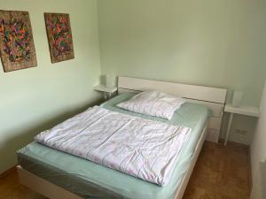 a bed in a white room with at Kleine Wohnung mit schönem Blick in die Schweiz - Grenznah in Murg