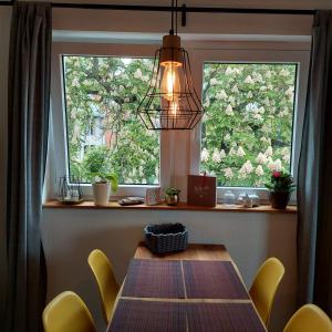 a dining room table with yellow chairs and a window at stilvolle Wohnung direkt in der City in Würzburg