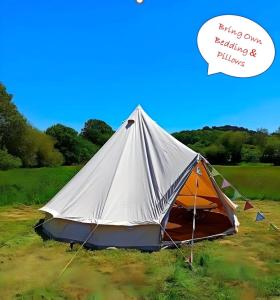 a tent in a field with a bubble saying flying own healing and planes at Dorset Glamping Fields in Corfe Mullen