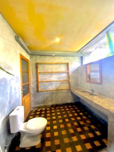 a bathroom with a toilet and a sink at Mangroove Bay Boutique Hostel in Banyuwedang