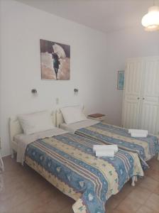 1 dormitorio con 2 camas y una foto en la pared en Syraino en Kolios