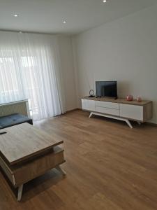 een woonkamer met een tv en een tafel bij Apartman Juric in Posušje