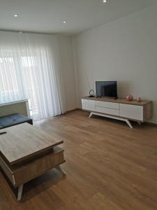 a living room with a tv and a table at Apartman Juric in Posušje