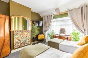 バーミンガムにあるLolite Homes - 4-5 Bed House 8 Minutes to NEC Airport Resorts World - Opal Serviced Homeのベッドルーム1室(ベッド2台、デスク付)