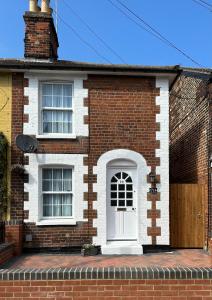 a brick house with a white door and windows at Cottage, 10 mins Train / River in Burnham-on-Crouch