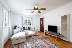 een woonkamer met een bank en een flatscreen-tv bij Gomez Gardens in Santa Fe