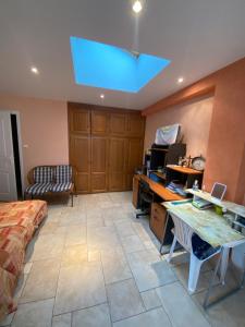 a bedroom with a bed and a desk with a computer at Chambre d'hôte La Blénie in Gignac