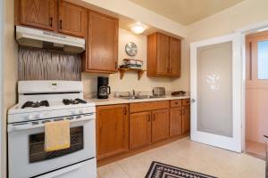 een keuken met houten kasten en een witte kookplaat oven bij Gomez Gardens in Santa Fe