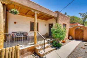 een huis met een veranda met een hek en een poort bij Gomez Gardens in Santa Fe