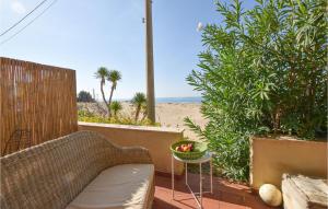 une terrasse avec un canapé et une table et la plage dans l'établissement Cozy Apartment In Donnalucata With Kitchen, à Donnalucata
