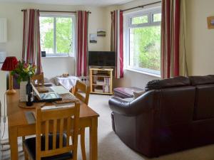 uma sala de estar com um sofá e uma mesa em Cairn Rigg em Rothbury