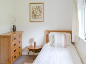 um quarto com uma cama e uma cómoda em madeira em Cairn Rigg em Rothbury