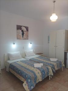 a bedroom with two beds and a painting on the wall at Syraino in Kolios