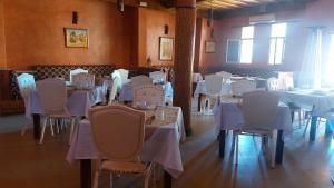 a dining room with white tables and chairs at Kasbat Aferdou in Er Rachidia