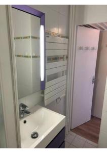 een badkamer met een wastafel en een spiegel bij Studio au coeur de la station des Menuires in Les Menuires
