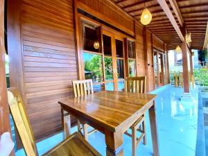 uma sala de jantar com uma mesa de madeira e cadeiras em Pondok Indah Bungalow Bingin em Uluwatu