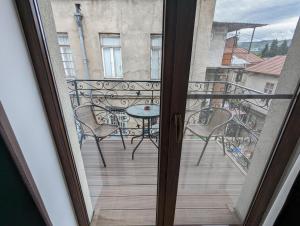 Habitación con vistas a un balcón con mesa y sillas. en Family Guest House, en Tiflis