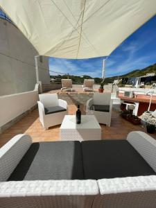 a patio with a table and chairs and an umbrella at Casa Santa Maria - Suite Mediterraneo in Ponza