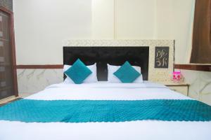 a bedroom with a large bed with blue pillows at Hotel Mayraa In Famaily in Mathura