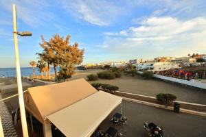 Blick auf einen Parkplatz mit einem weißen Zelt in der Unterkunft Las Palmeras in Playa La Garita - beach apartment in La Garita