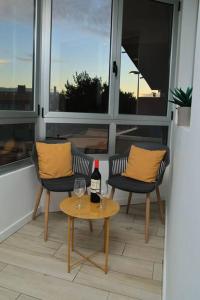 una mesa con una botella de vino y dos sillas en Las Palmeras in Playa La Garita - beach apartment, en La Garita