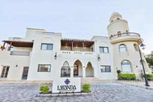 a large white building with a sign in front of it at Lavanda Boutique Suites Tala Bay in Aqaba