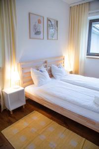 ein Bett mit weißer Bettwäsche und Kissen in einem Schlafzimmer in der Unterkunft Gutshof zum Wurzgarten in Hainbach