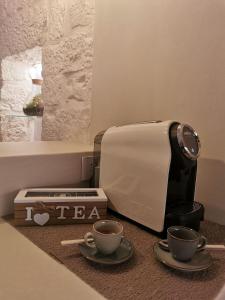 a toaster and two cups of coffee on a counter at A casòdd' - Luxury Suite in Ceglie Messapica +9 photos