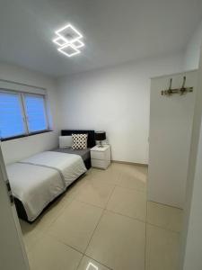 een witte slaapkamer met een bed en een raam bij Exklusive Flughafen-Messe Apartment nähe Düsseldorf in Duisburg