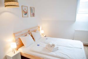 a bedroom with a white bed with two towels on it at Gutshof zum Wurzgarten in Hainbach