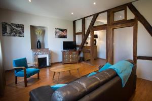 a living room with a leather couch and a table at Hôtel De La Couronne in Riquewihr