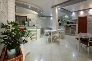 cocina y comedor con mesas y sillas en Apart & Rooms Fotinov, en Burgas