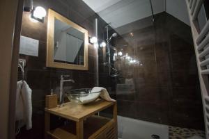 uma casa de banho com um lavatório e um chuveiro em Hôtel De La Couronne em Riquewihr