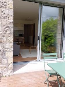 una puerta corredera de cristal de una casa con sala de estar en La Villa Bompard 48M2 Cœur de ville avec terrasse, en Rodez