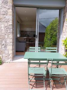 Une table de pique-nique et des chaises vertes sont disponibles sur la terrasse. dans l'établissement La Villa Bompard 48M2 Cœur de ville avec terrasse, à Rodez