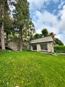 La Villa Bompard 48M2 Cœur de ville avec terrasse في روديه: منزل حجري في ميدان عشب أخضر
