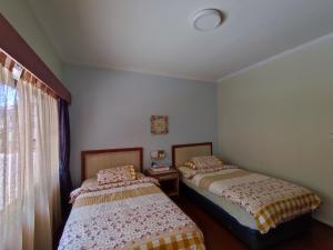 um quarto com 2 camas e uma janela em Mary Apt @ Equatorial Hill Resort em Cameron Highlands