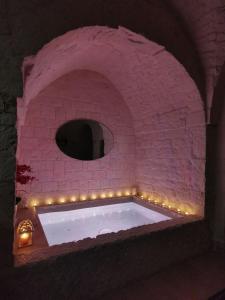 a bath tub in a brick wall with lights at A casòdd' - Luxury Suite in Ceglie Messapica