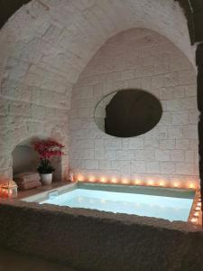 a bath tub in a stone wall with lights at A casòdd' - Luxury Suite in Ceglie Messapica