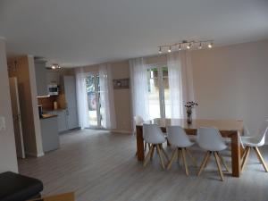 a dining room with a wooden table and white chairs at Ferienhaus Sonnenzauber 1 in Walsrode