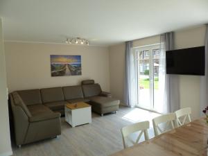 uma sala de estar com um sofá e uma mesa em Ferienhaus Sonnenzauber 2 em Walsrode