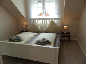 uma cama com duas almofadas debaixo de uma janela em Ferienhaus Sonnenzauber 2 em Walsrode