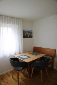 einen Tisch und Stühle in einem Zimmer mit Fenster in der Unterkunft Studio CHic in Niederweningen