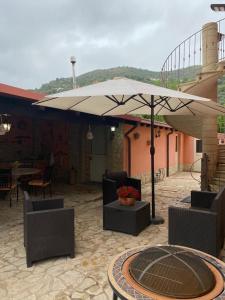 une terrasse avec une table et un parasol dans l'établissement Casa Vacanze Ileana, à Patti