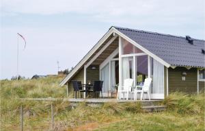 HavrvigにあるBeautiful Home In Hvide Sande With 2 Bedrooms, Sauna And Wifiの小屋(ポーチ、白い椅子付)