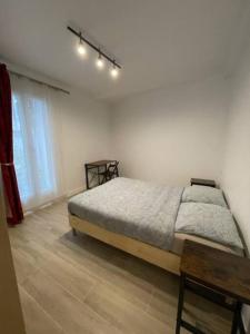 パリにあるParis Nordmann superbe appartement 2 piècesのベッドとテーブルと窓のある寝室
