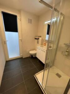 a bathroom with a shower and a toilet and a glass door at Paris Nordmann superbe appartement 2 pièces in Paris