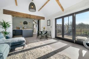 een woonkamer met een bank en een tafel bij Ysgubor Twt, Monknash in Monknash