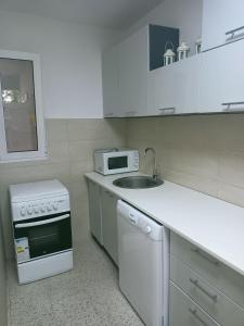 Apartman Anika في سوتوموري: مطبخ أبيض مع حوض وميكروويف