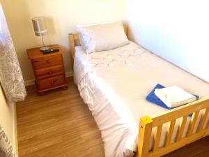 a small bedroom with a bed with a nightstand and a bed sidx sidx sidx at Invercaul House in Inverness